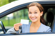 girl in a car showing a key and an empty white card