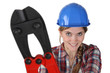 female plumber holding giant spanner
