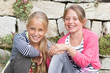 Photo: Two Girls smiling in front of Stone Wall Two Girls smiling in front of Stone Wall
