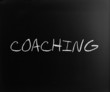 "Coaching" handwritten with white chalk on a blackboard