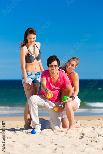 Foto: Mann und Frauen spielen Boule am Strand Mann und Frauen spielen Boule am Strand