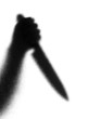 Knife in a hand. Silhouette. Photographed through the textured g