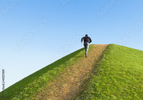 Photo: Pathway up the hill against the sky. Man ran to the top. Pathway up the hill against the sky. Man ran to the top.