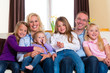 Familie auf der Couch daheim im Wohnzimmer