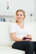Photo: Woman sitting on a sofa with a book in her hands Woman sitting on a sofa with a book in her hands