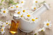 Photo: essential oil and camomile flowers in mortar essential oil and camomile flowers in mortar