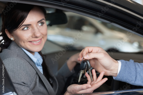 Photo: Smiling woman receiving keys from a man Smiling woman receiving keys from a man