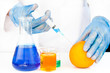 Chemist injecting product in an orange