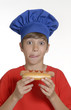 Niño chef sujetando un hotdog,comiendo perro caliente.