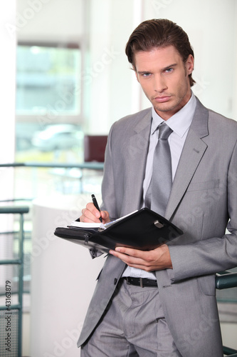 Photo: Businessman holding diary Businessman holding diary
