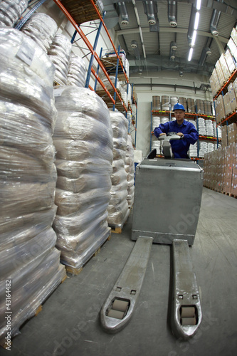 Photo: Forklift operator uniform and helmet at work in warehouse Forklift operator uniform and helmet at work in warehouse