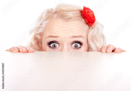 Foto: Funny girl hiding behind a table Funny girl hiding behind a table