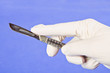 Surgical glove with metal scalpel