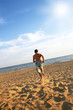 Photo: sporty young man running on beach sporty young man running on beach