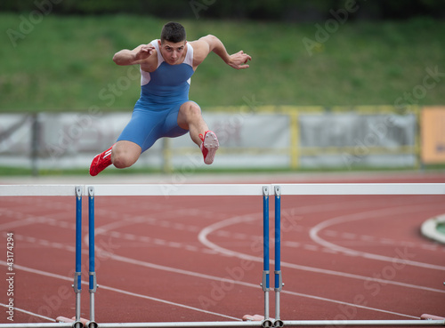 Photo: Professional sprinter jumping over a hurdle Professional sprinter jumping over a hurdle