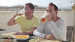 Two happy friends drinking beer, outdoors