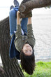 Photo: Young teen girl hanging upside down on tree limb Young teen girl hanging upside down on tree limb