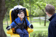 Father pushing disabled son  on handicap swing