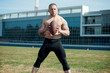 Caucasian american football player holding the ball