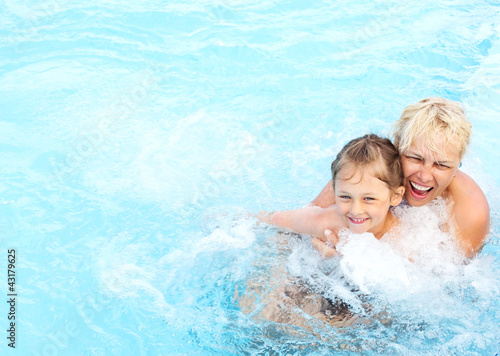 Photo: woman and girl swimming in the pool woman and girl swimming in the pool
