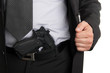 Man in suit showing gun tucked in pants