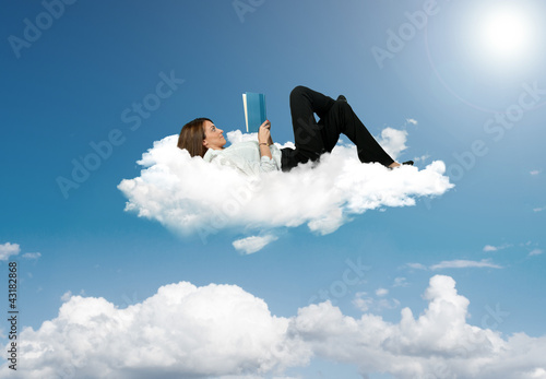 Photo: Businesswoman reading a book in a cloud Businesswoman reading a book in a cloud