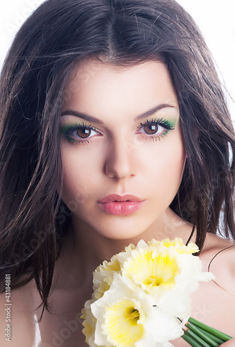 Photo: Beautiful girl face with spring flower - daffodil narcissus Beautiful girl face with spring flower - daffodil narcissus