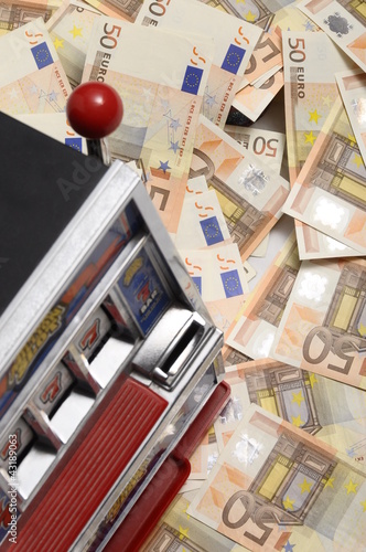 Photo: Slot machine and Lot of money fifty euros banknotes Slot machine and Lot of money fifty euros banknotes