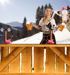 sexy woman in snow and mountains serving beer