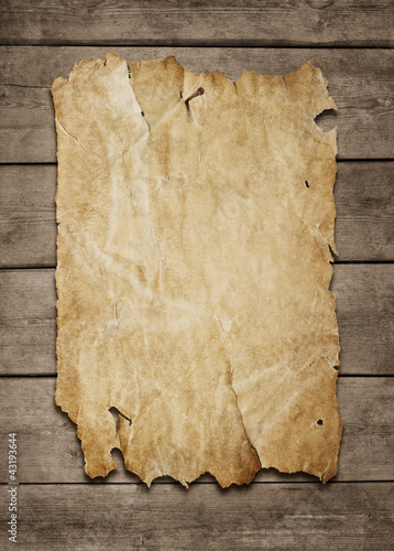 Photo: Old paper sheet nailed to a grunge wooden background with copy s Old paper sheet nailed to a grunge wooden background with copy s