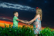 group of happy children playing on meadow, sunset, summertime