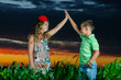 group of happy children playing on meadow, sunset, summertime