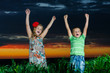 group of happy children playing on meadow, sunset, summertime
