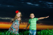 group of happy children playing on meadow, sunset, summertime