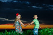 group of happy children playing on meadow, sunset, summertime