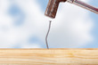 Crooked nail in the wooden board with a hammer