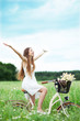 Foto: Woman riding bicycle in wildflower field Woman riding bicycle in wildflower field