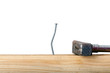 Crooked nail in the wooden board with a hammer