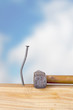 Crooked nail in the wooden board with a hammer