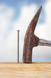 Hammer and nail with wooden board