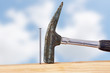 Hammer and nail with wooden board