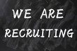 Concept of we are recruiting written on smudged blackboard
