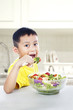 Asian child eating salad