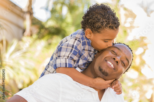 Photo: Mixed Race Father and Son Playing Piggyback in Park Mixed Race Father and Son Playing Piggyback in Park