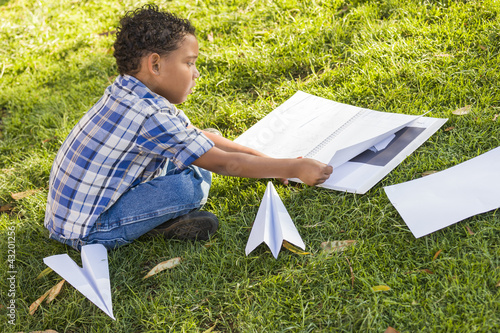 Photo: Mixed Race Boy Learning How to Fold Paper Airplanes Mixed Race Boy Learning How to Fold Paper Airplanes