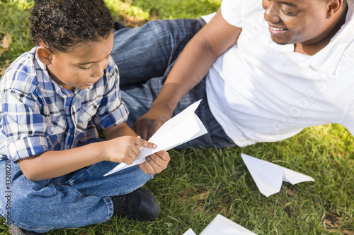 Photo: Mixed Race Father and Son Playing with Paper Airplanes Mixed Race Father and Son Playing with Paper Airplanes