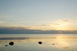 Calm water with black rocks in sunset