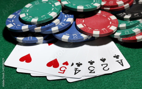 Photo: Cards and chips for poker on green table Cards and chips for poker on green table
