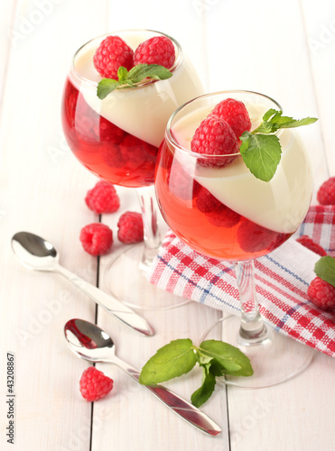 Photo: fruit jelly with raspberries in glasses on wooden table fruit jelly with raspberries in glasses on wooden table