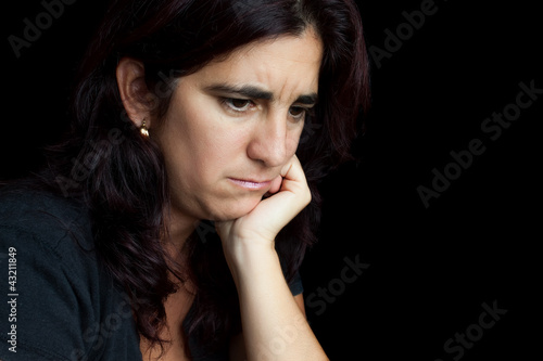 Photo: Portrait of a sad and depressed hispanic woman isolated on black Portrait of a sad and depressed hispanic woman isolated on black